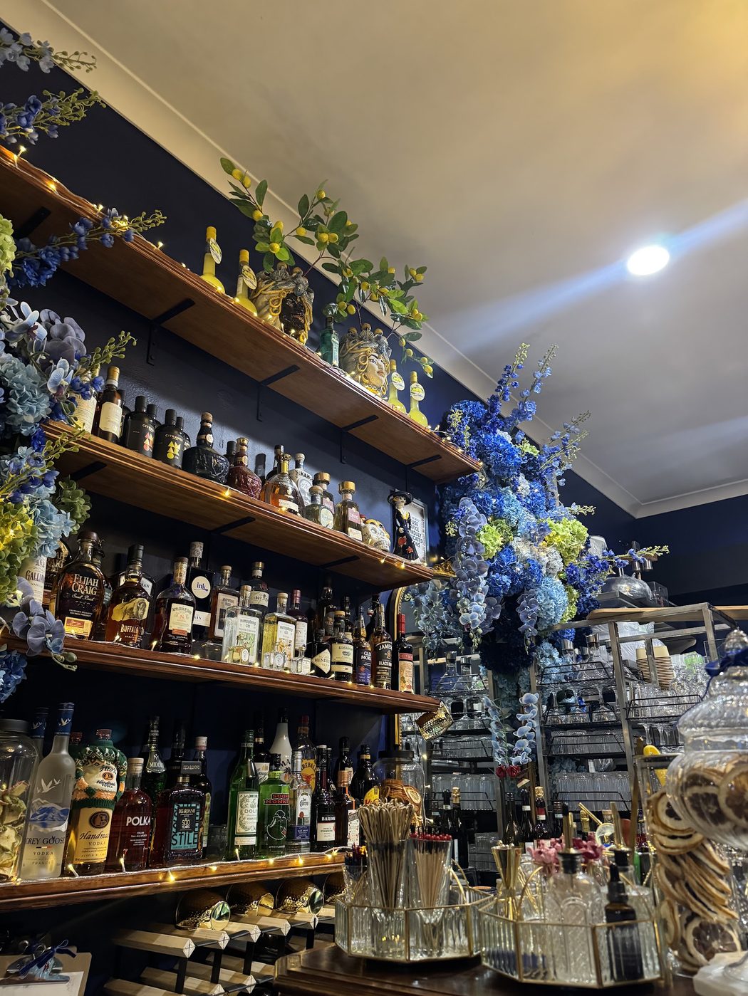 Back bar shelves stocked with spirits at Bottega Bar